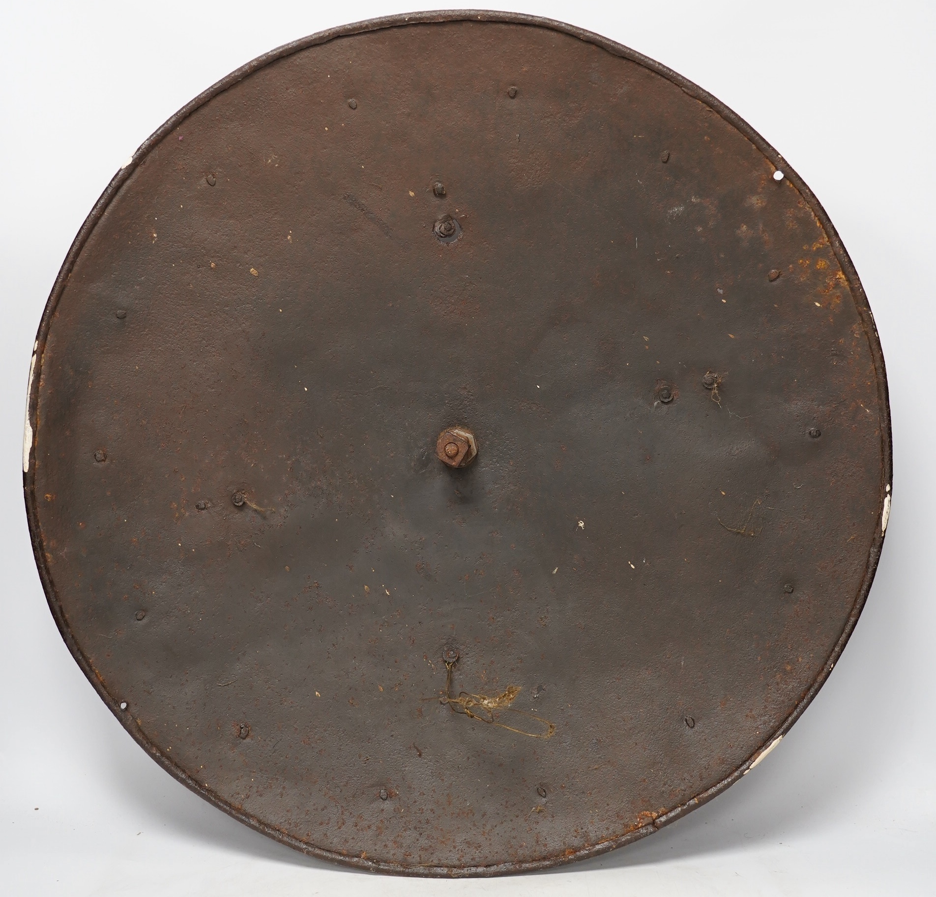 A 19th century iron shield with centre spike, formally part of a suit of armour, 57.5cm diameter. Condition - poor, surface rust and pitting overall